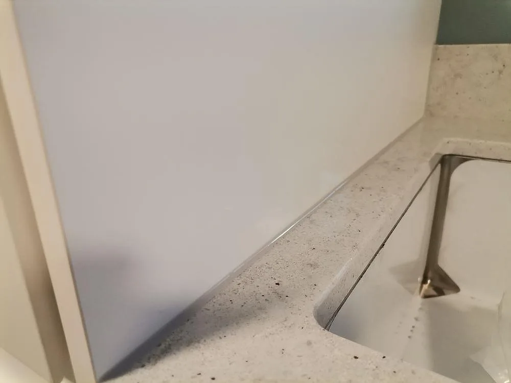 Närbild på den polerade kanten och ådringen i Quarella Bianco Savoia vid hon i ett tvättrum i Hässelby.