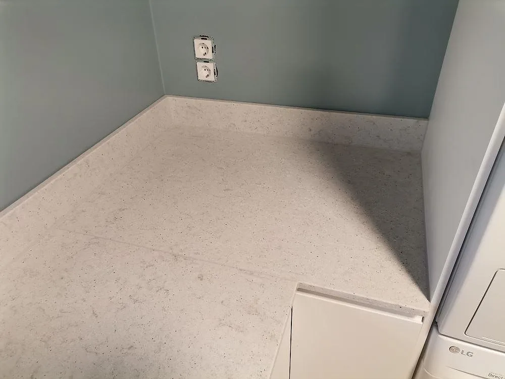 Bänkskiva i Quarella Bianco Savoia uppifrån som visar den jämna, ljusa kompositytan i ett grovkök i Hässelby.