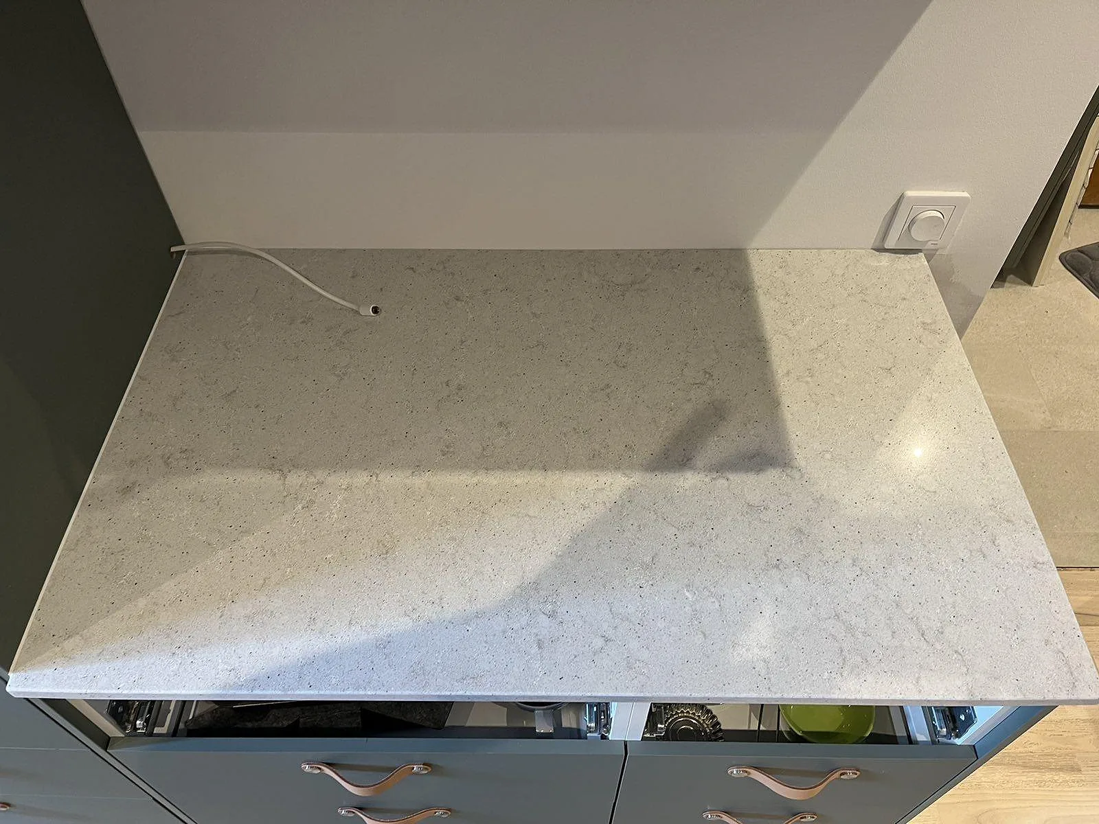 Närbild ovanifrån på polerad Quarella Bianco Savoia bänkskiva i komposit, ljus ådringsfri yta, kök i Malmö.