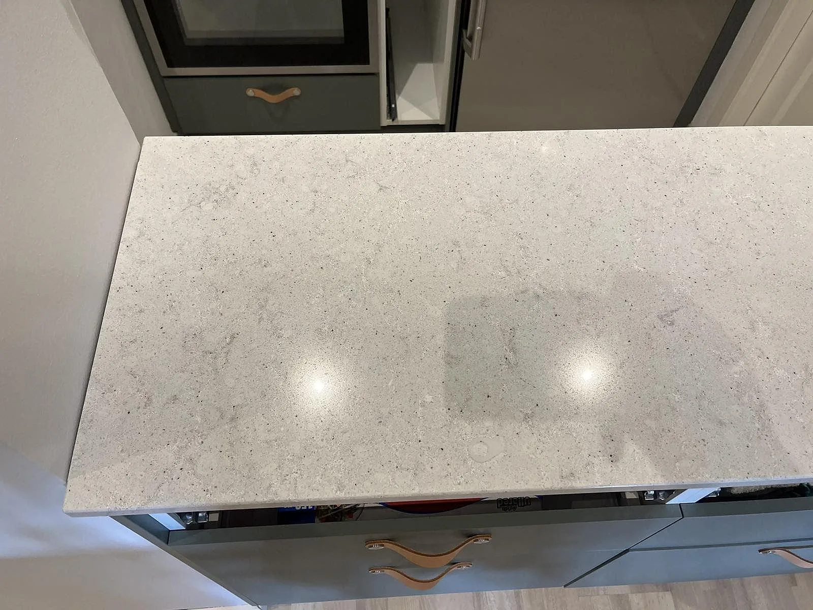 Vit Quarella Bianco Savoia kompositbänkskiva i ett kök i Malmö, sedd ovanifrån vid köksdelen med mikrovågsugn.