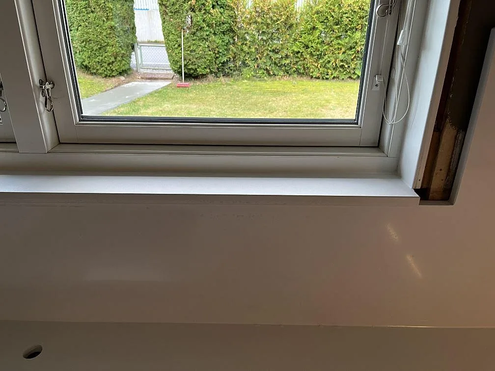 Vit fönsterbänk i Quarella Blanco Sal kvartskomposit monterad under köksfönstret i Tjörnarp.