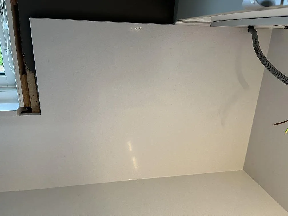 Vitt stänkskydd i Quarella Blanco Sal vid köksfönstret, polerad kvartskomposit, i Tjörnarp.