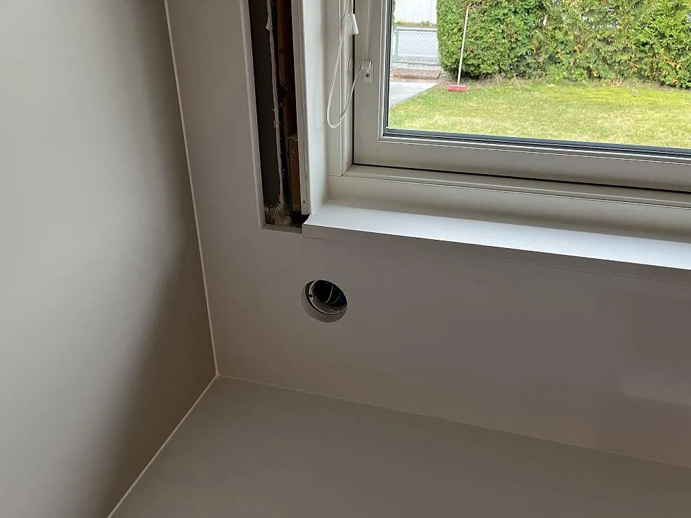 Vit fönsterbänk och vägghörn i Quarella Blanco Sal kvartskomposit vid köksfönstret i Tjörnarp.