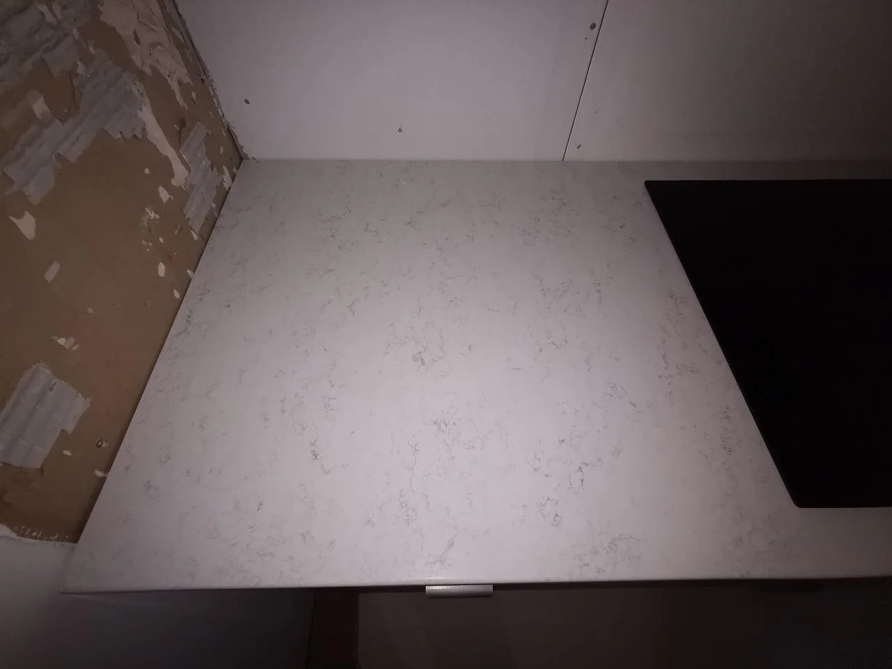 Bänkyta i polerad Quarella Palatino vid diskhon, fotad under montering i ett kök i Åkarp.