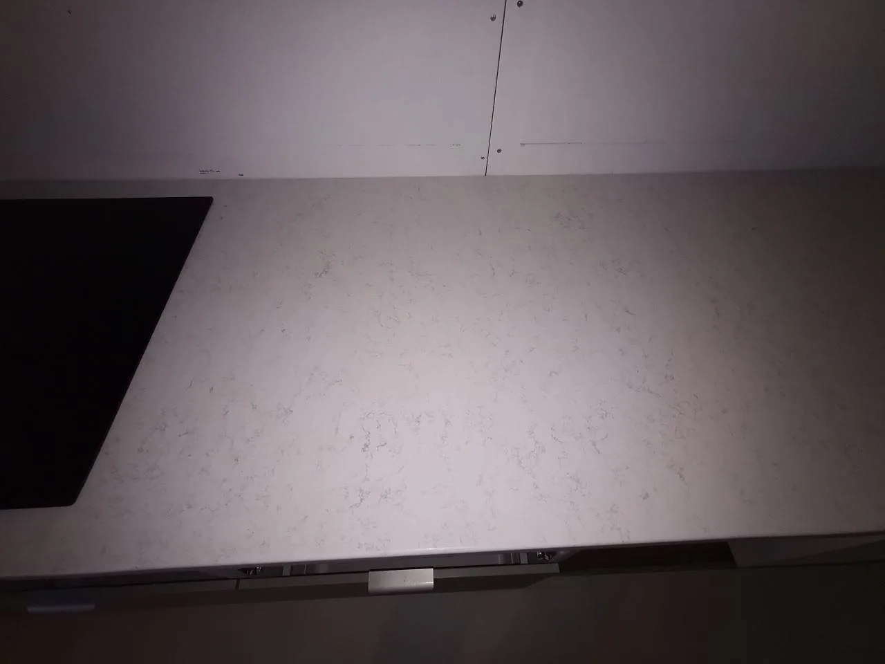 Ovanpåliggande induktionshäll på polerad Quarella Palatino köksbänkskiva i Åkarp.
