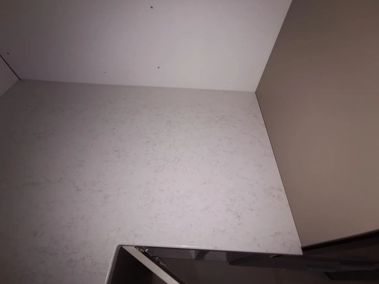 Hörn av köksbänkskivan i polerad Quarella Palatino vid diskhon, kök i Åkarp.
