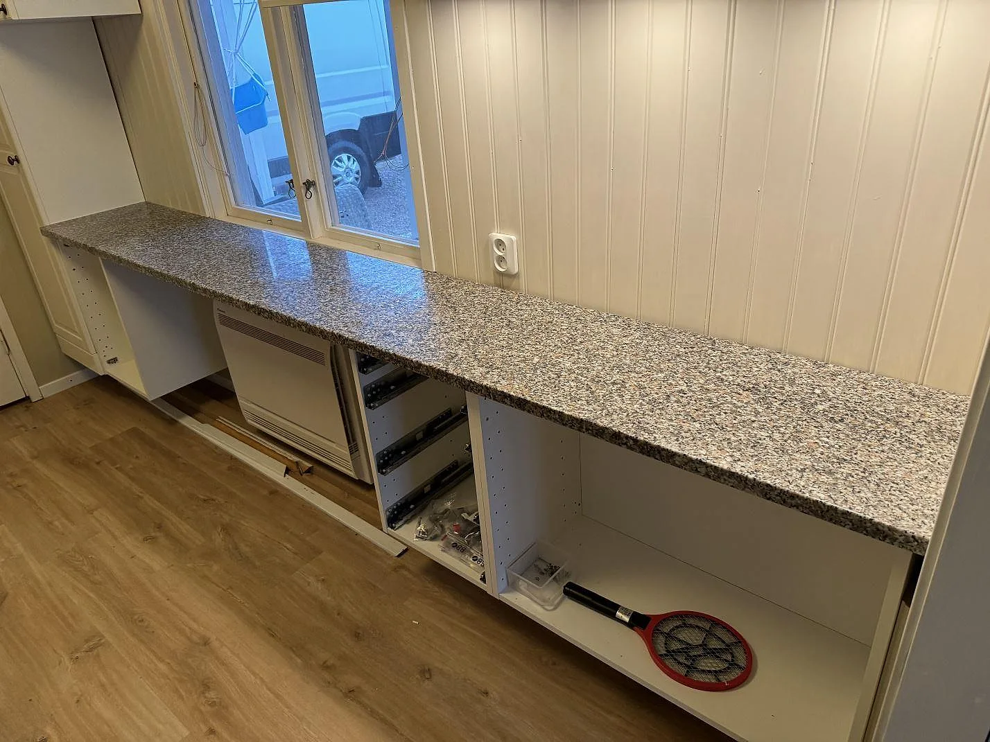 Köksbänkskiva i polerad Rosa Beta granit, 30 mm, monterad under fönster på vita stommar i Braastad.