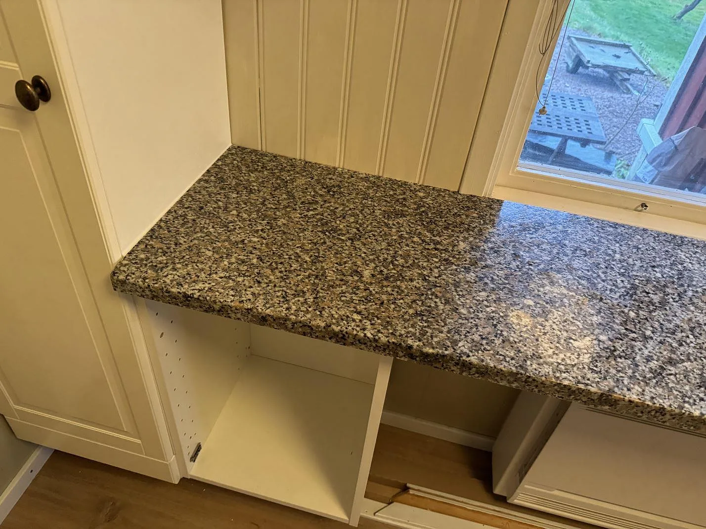Detalj av 30 mm polerad Rosa Beta granit vid fönster och vita köksstommar i Braastad.