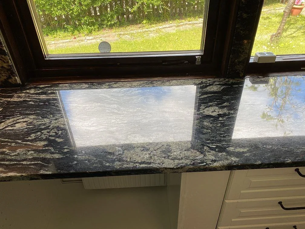 Polerad fönsterbänk i svart Sensa Indian Black granit med spegelblank yta i ett kök i Malmö.