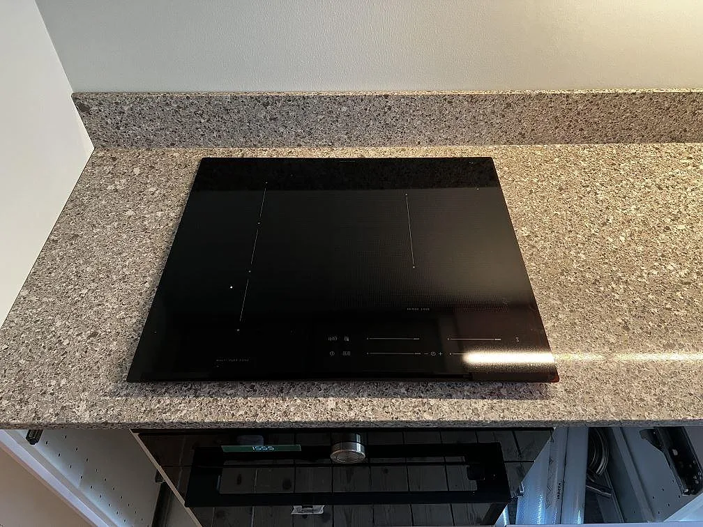 Svart induktionshäll monterad i en polerad köksbänkskiva av Silestone Alpina White i Göteborg.