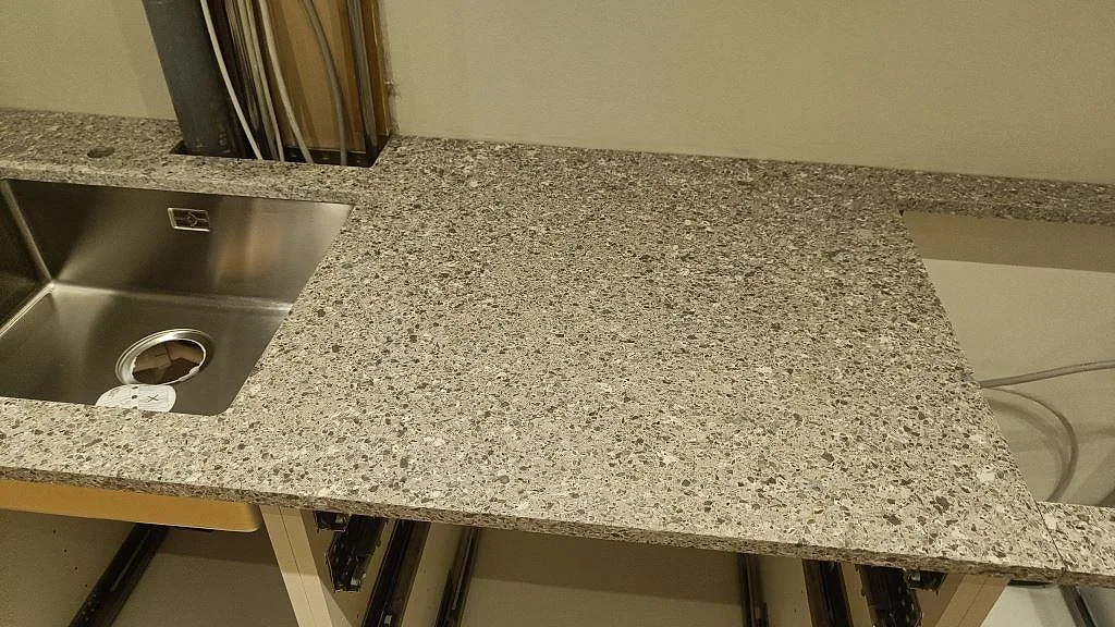 Silestone Alpina White köksbänkskiva med rostfri diskho och hällöppning i ett pågående montage i København S.
