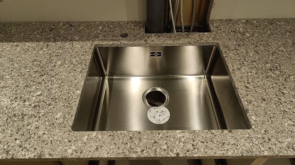 Rostfri diskho under Silestone Alpina White bänkskiva, matt Mocka, i ett kök i København S.