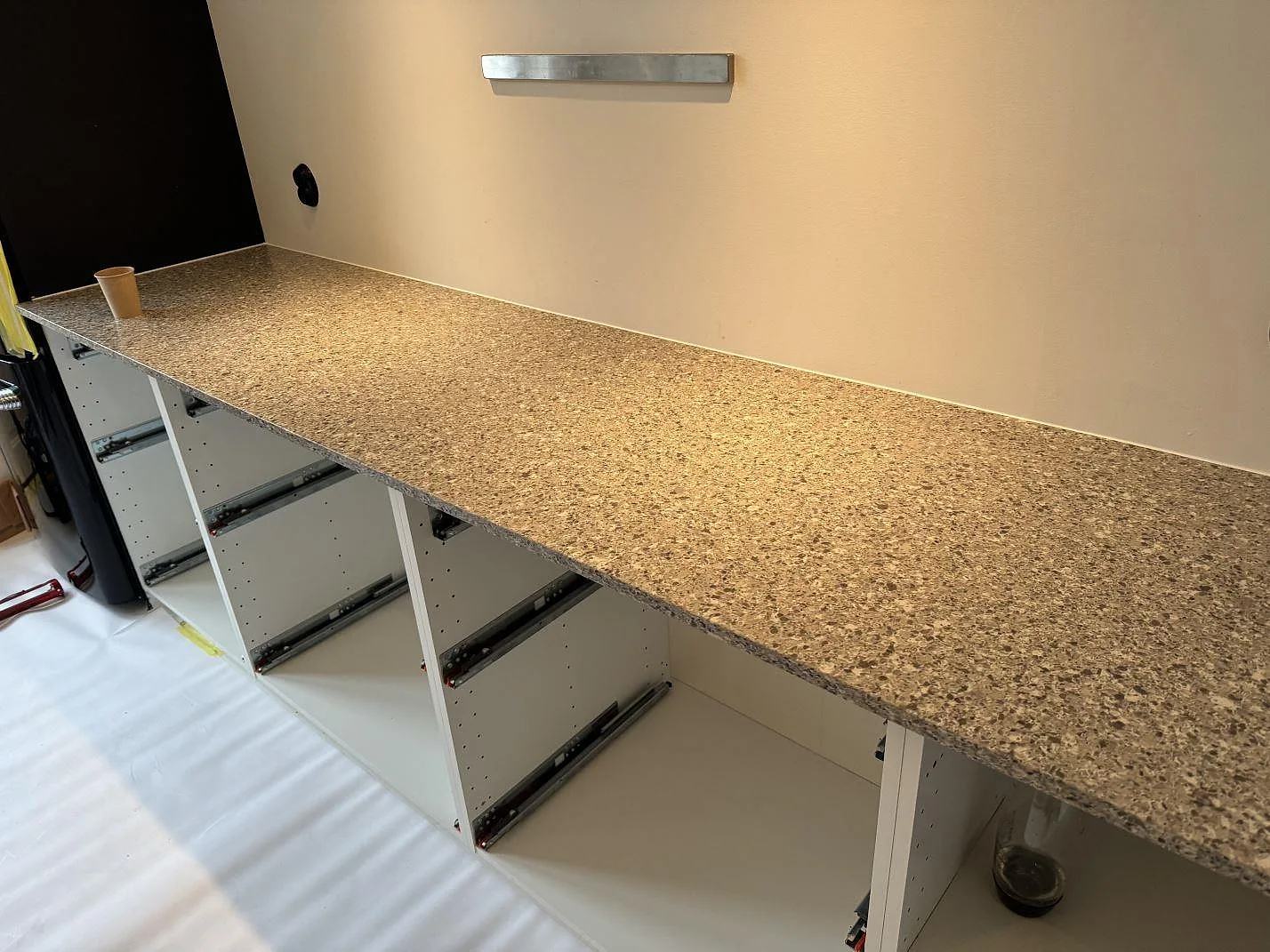 Lång köksbänkskiva i Silestone Alpina White, 20 mm Mocka, monterad på vita köksstommar i Malmö.