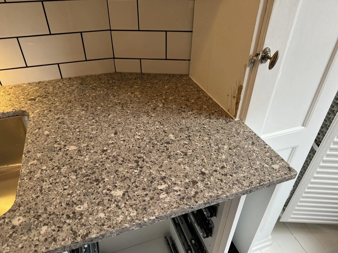 Detalj av Silestone Alpina White som köksbänkskiva vid diskhon, med vit kakelvägg i Malmö.