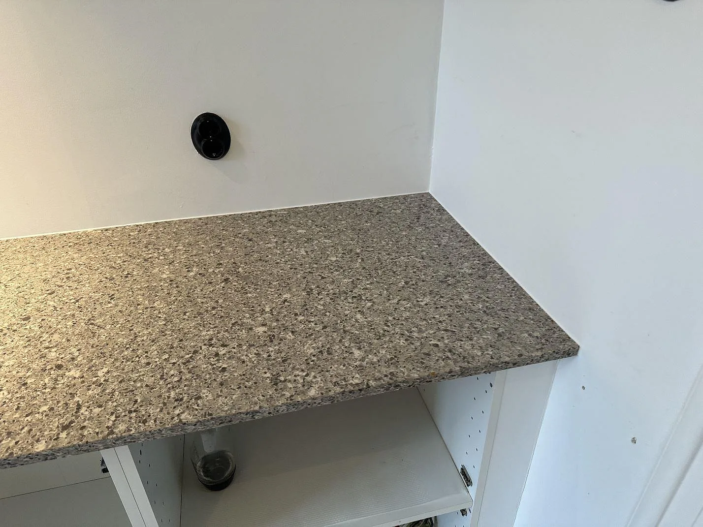 Närbild på installerad köksbänkskiva i Silestone Alpina White, 20 mm Mocka, mot ljus vägg i Malmö.