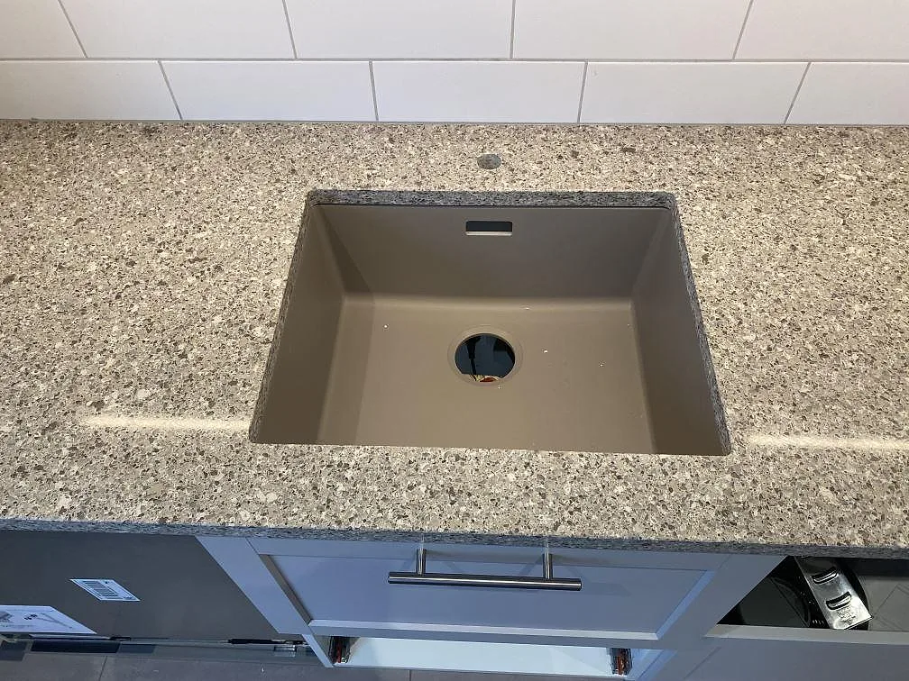 Detalj av polerad Silestone Alpina White vid diskhon, med ljus kvartskomposityta i kök i Malmö.