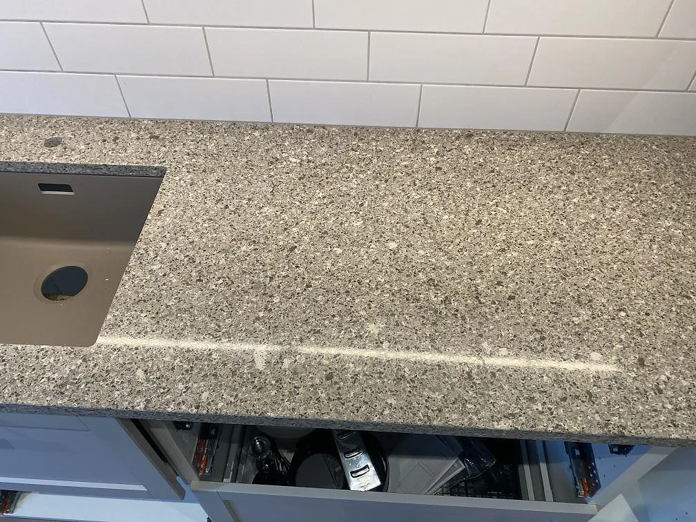 Närbild på 30 mm polerad Silestone Alpina White över köksstommar, med diskhon i kanten av bilden i Malmö.