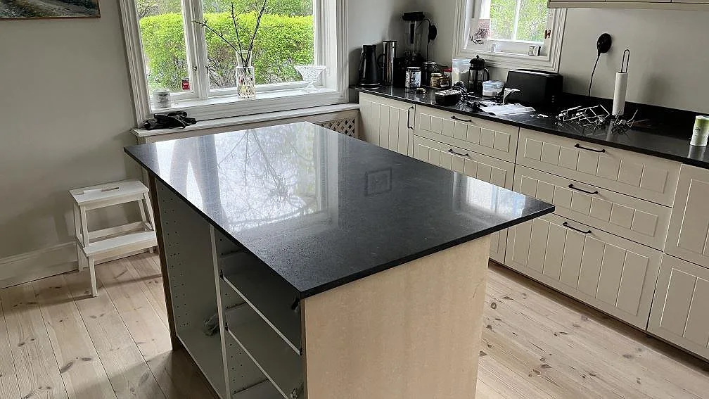 Köksbänkskiva och köksö i mörk blågrå Silestone Arden Blue, polerad kvartskomposit i ett kök i Bromma.