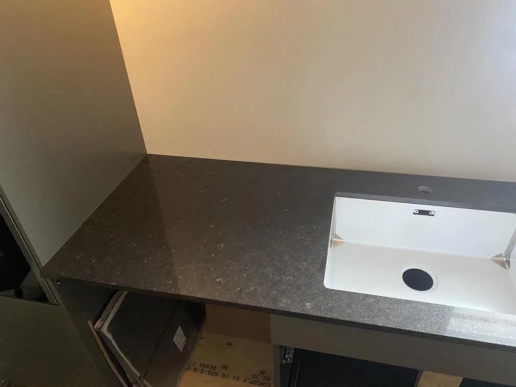 Närbild på diskho och bänkskiva i Silestone Arden Blue, polerad kvartskomposit, i ett kök i Nättraby.