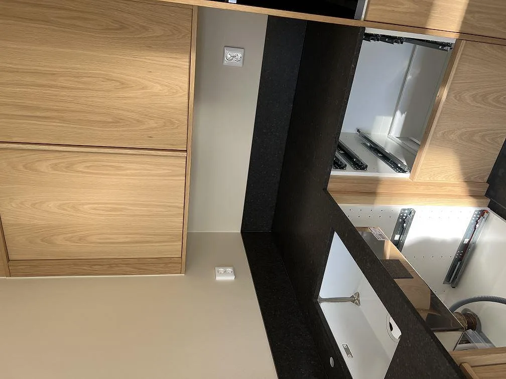 Närbild av Silestone Arden Blue bänkskiva och köksö med träinredning, matt Mocka-finish och diskhoöppning i Sävedalen.