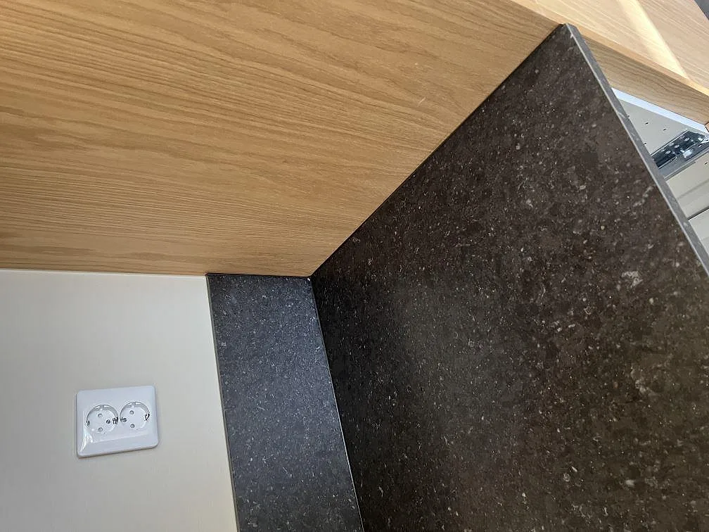 Detalj av 12 mm stänkskydd och 20 mm Silestone Arden Blue bänkskiva med mörk matt komposityta i Sävedalen.