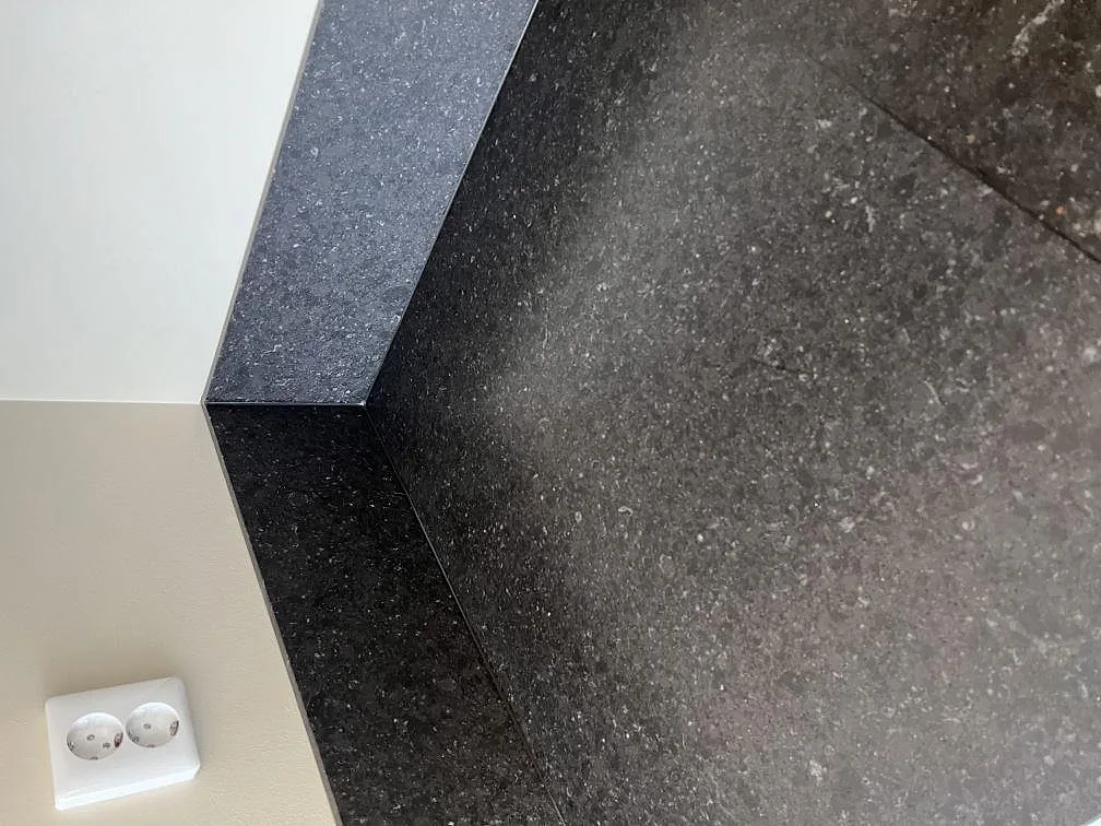Mörk Silestone Arden Blue bänkskiva med uppvikt stänkkant och matt, lågblank yta i Sävedalen.