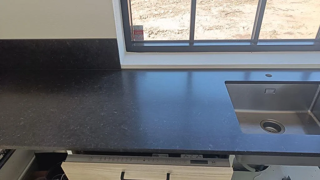 Väggbänk i Silestone Arden Blue, matt Mocka, med rostfri diskho, blandarhål och stänkskydd i köket i Smedstorp.