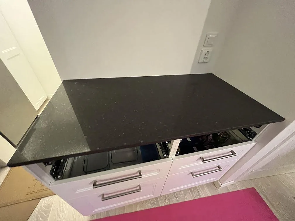Närbild på mörk polerad Silestone Arden Blue som köksbänkskiva över vita skåp under montering i Strängnäs.