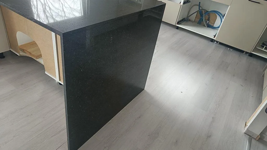 Närbild på den svävande gaveln i polerad Silestone Arden Blue där kvartskompositens spräckliga blågrå yta syns i ett kök i Torslanda.