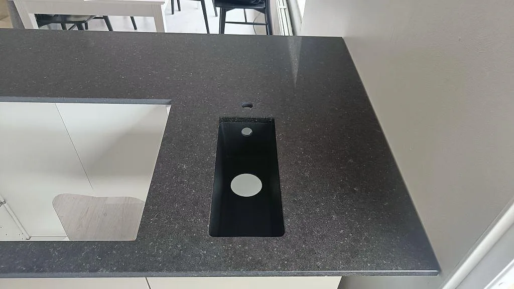 Bänkskiva i blågrå Silestone Arden Blue med urtag för underlimmad diskho och borrat blandarhål i ett kök i Torslanda.