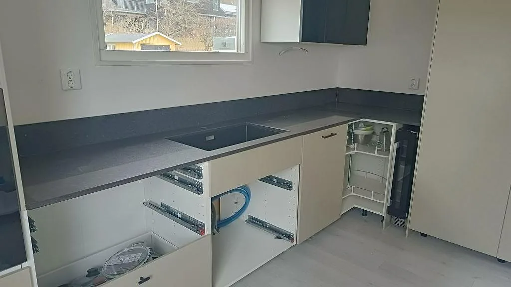 Polerad köksbänkskiva i Silestone Arden Blue längs väggen med urtag för underlimmad diskho i ett kök i Torslanda.