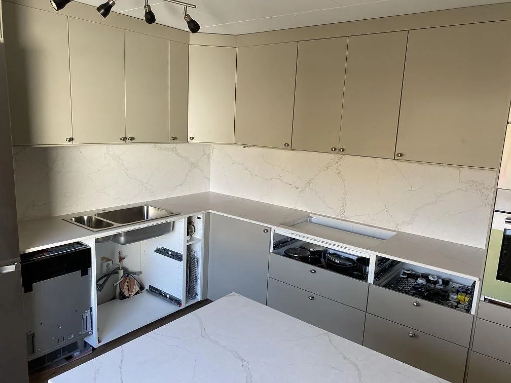 Köksbänkskiva i matt Silestone Blanc Elysee komposit med matchande stänkskydd i ett kök i Vinslöv.