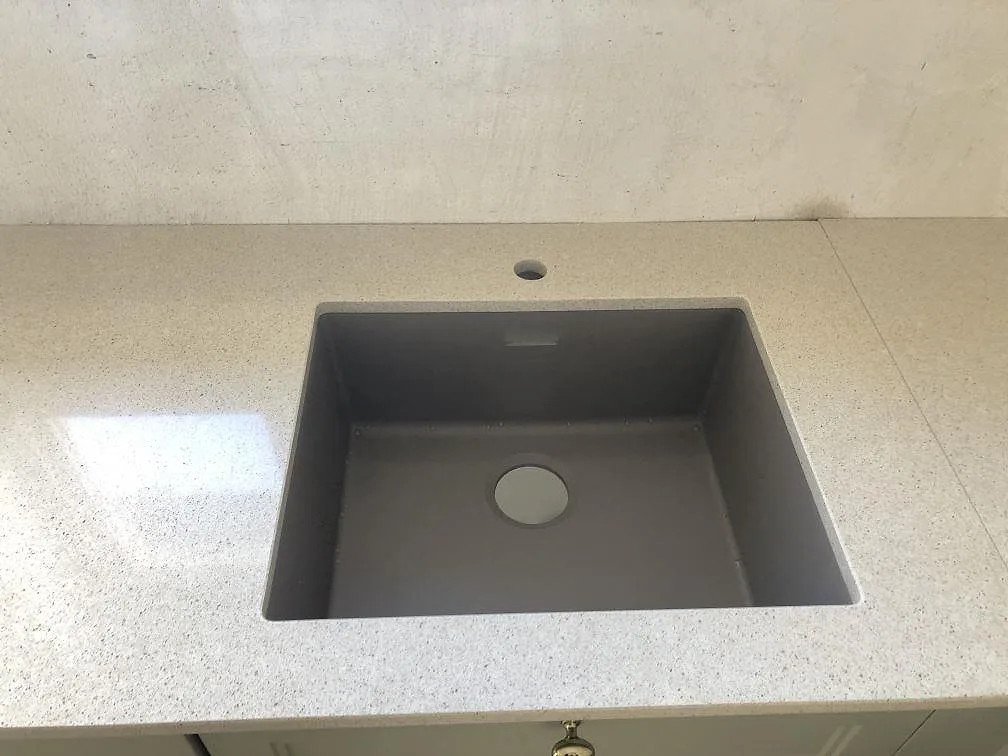 Underlimmad grå kompositdiskho i vit Silestone Blanco City köksbänkskiva i Ängelholm.