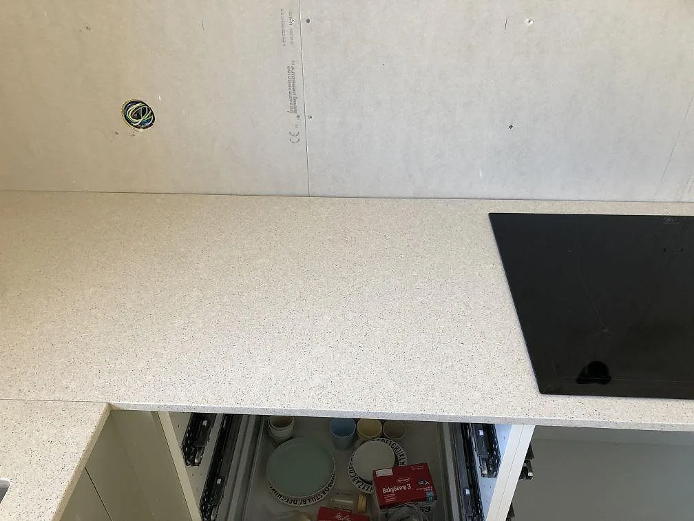 Vit Silestone Blanco City som bänkskiva med öppna lådstommar under montering i ett kök i Ängelholm.