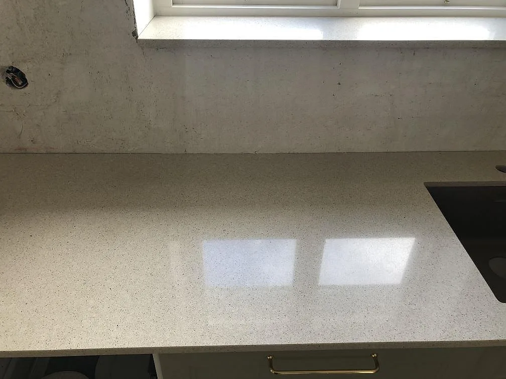 Närbild på den ljusa spräckliga ytan i Silestone Blanco City köksbänkskiva i Ängelholm.