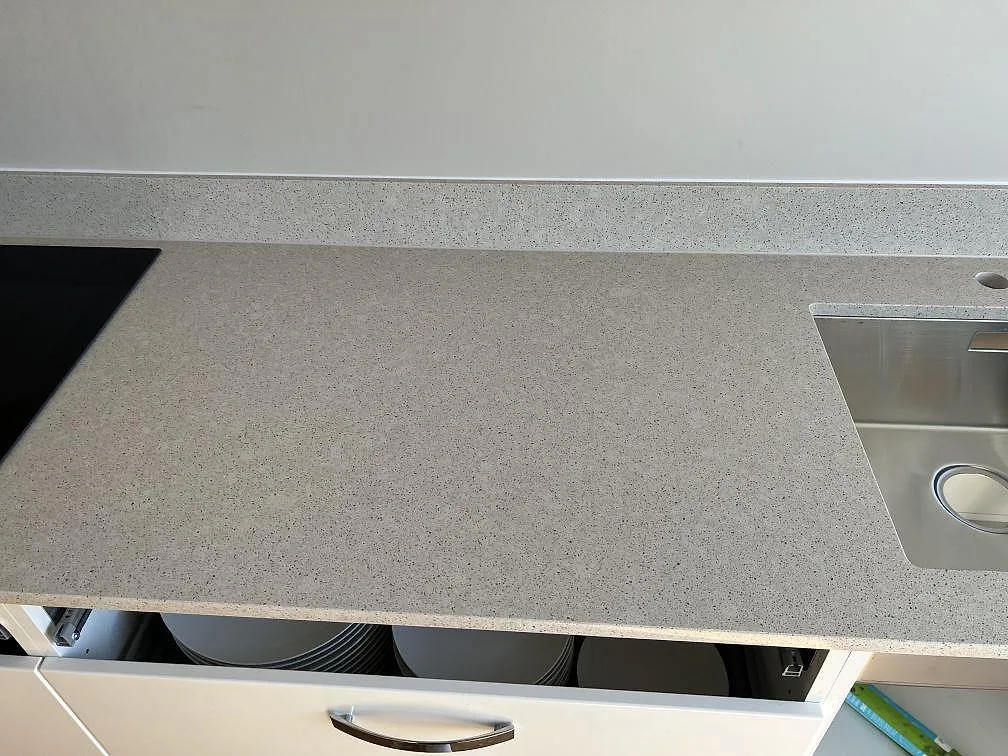 Polerad Silestone Blanco City bänkskiva i komposit mellan svart häll och rostfri diskho i kök i Bjärred.