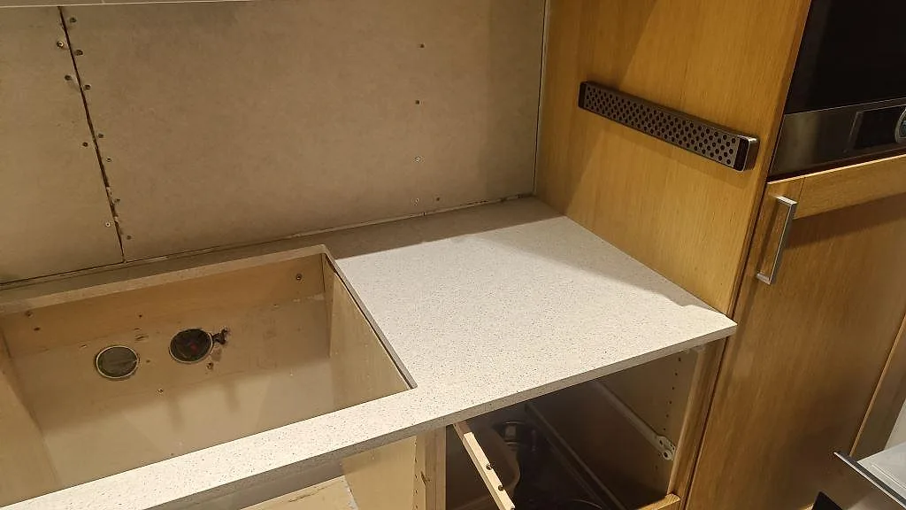 Hörn på köksbänk i polerad Silestone Blanco City komposit vid urtag och högskåp i Malmö.