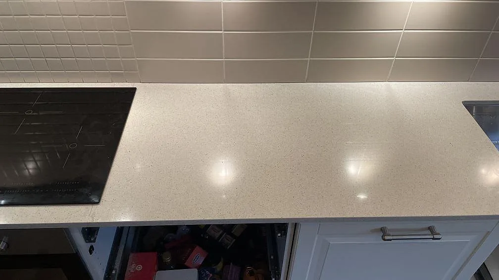 Ljus Silestone Blanco City bänkskiva i polerad komposit mellan häll och rostfri diskho i ett kök i Tygelsjö.