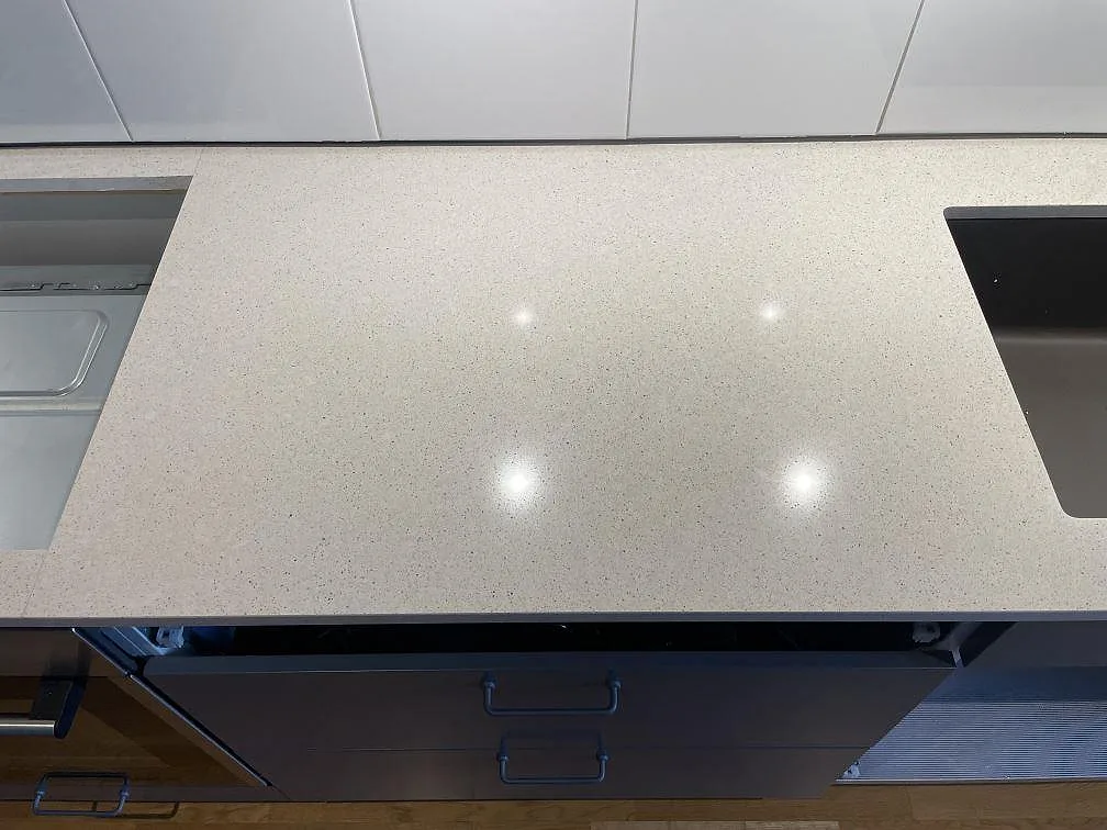Närbild av polerad Silestone Blanco City i 20 mm med ljus komposityta och öppningar i arbetsytan i Uppsala.
