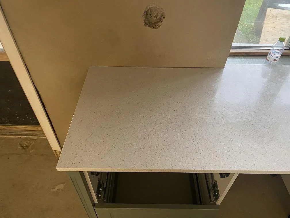Väggmonterad köksbänkskiva i polerad Silestone Blanco Maple 14 med ljus finprickig komposit i Klagshamn.