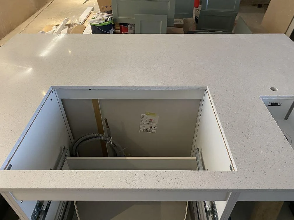 Polerad köksbänkskiva i Silestone Blanco Maple 14 med stort rektangulärt urtag i köksö i Klagshamn.
