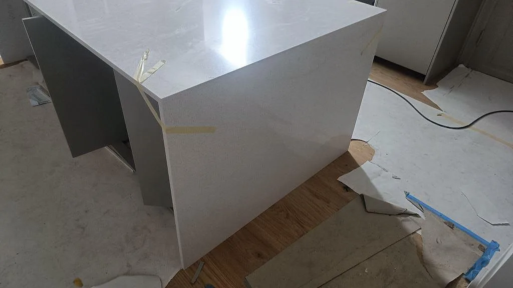 Gavel och arbetsyta på köksö i polerad Silestone Blanco Maple 14 under montering i Lund.
