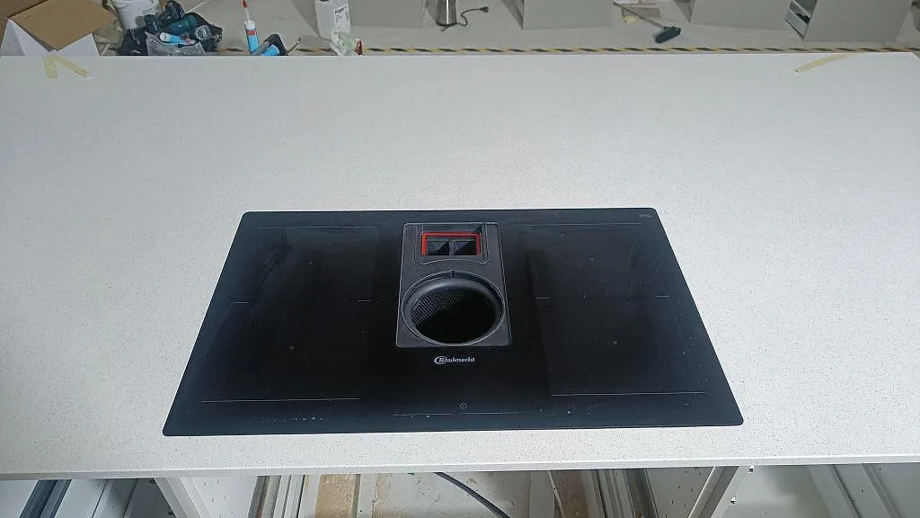 Detalj av svart induktionshäll monterad i vit polerad Silestone Blanco Maple 14 i ett kök i Lund.