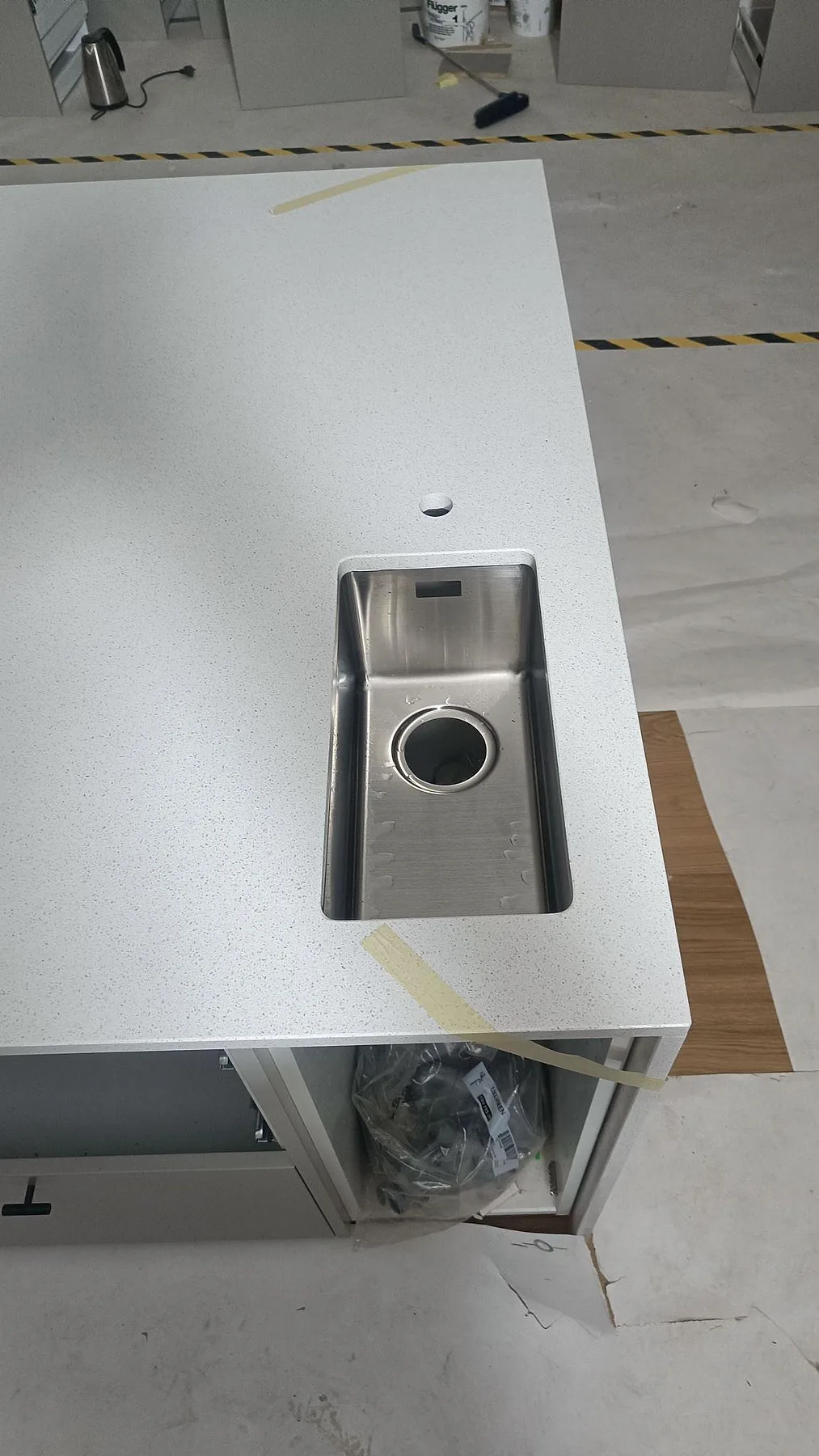 Närbild på underlimmad rostfri diskho i polerad Silestone Blanco Maple 14 på en köksö i Lund.