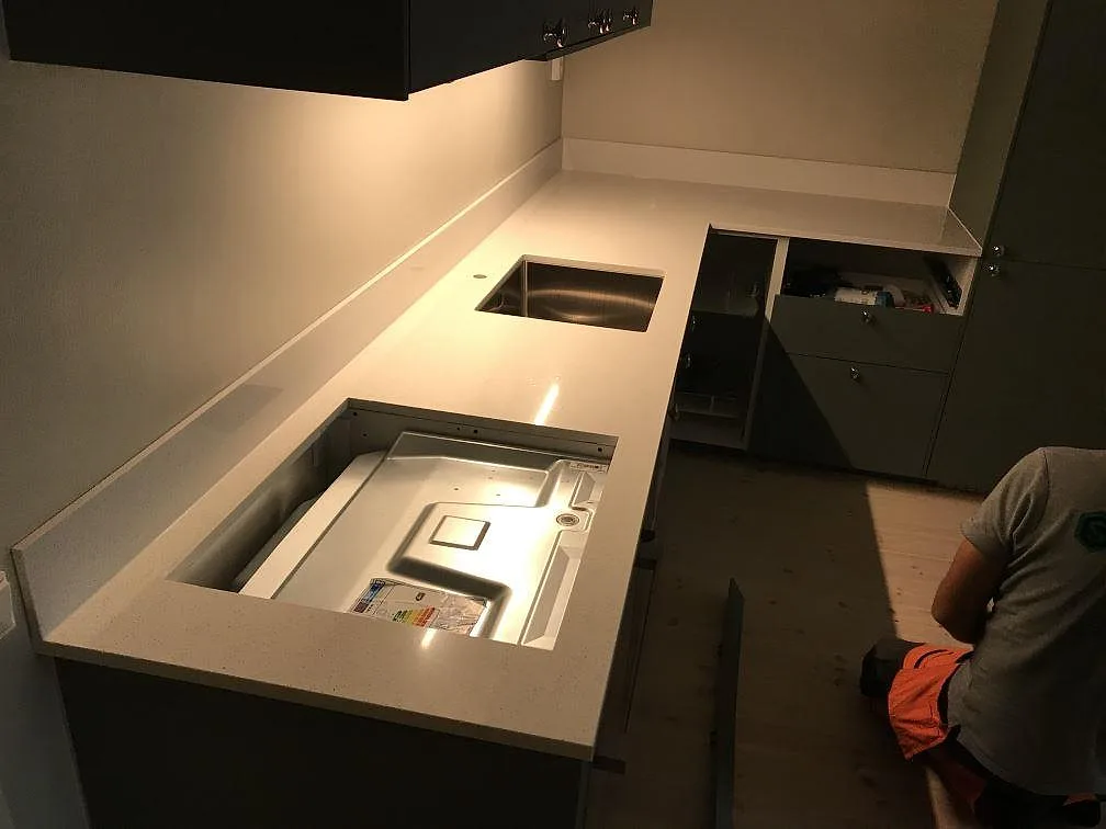 Köksbänkskiva i polerad Silestone Blanco Maple 14, ljus komposit, med rostfri diskho och hällöppning i ett kök i Malmö.