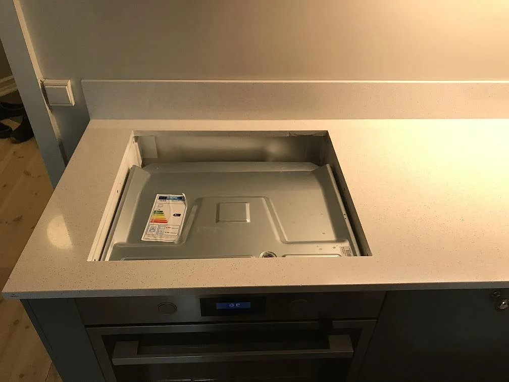 Hällöppning i polerad Silestone Blanco Maple 14 ovanför inbyggnadsugn i ett kök i Malmö.