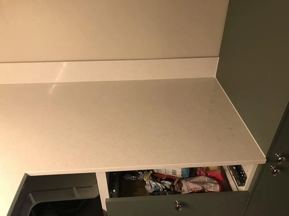 Rak arbetsyta i polerad Silestone Blanco Maple 14 med uppvikt stänkkant och mörka köksskåp i Malmö.