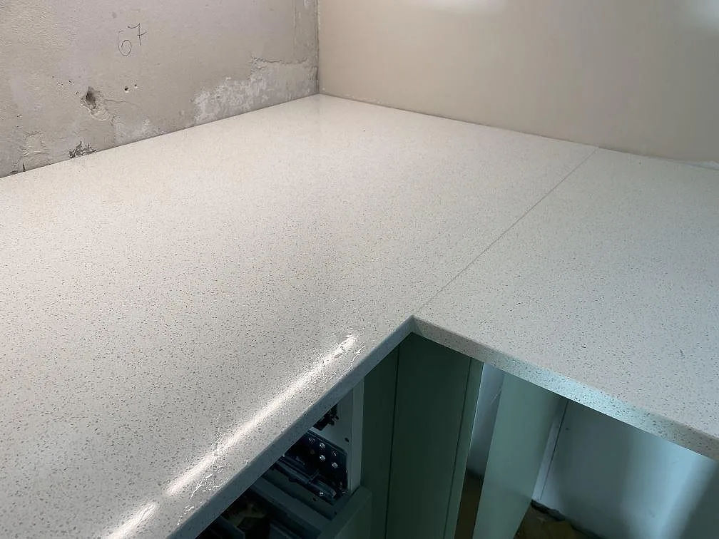 Hörn och skarv i polerad Silestone Blanco Maple 14 med blank reflektion och fin spräcklig yta i ett kök i Malmö.