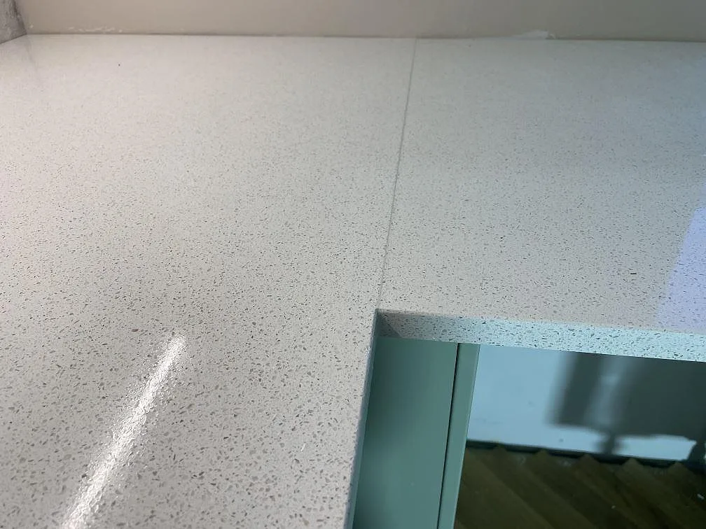 Detalj av polerad Silestone Blanco Maple 14 kvartskomposit med ljus spräcklig yta och öppet urtag i ett kök i Malmö.
