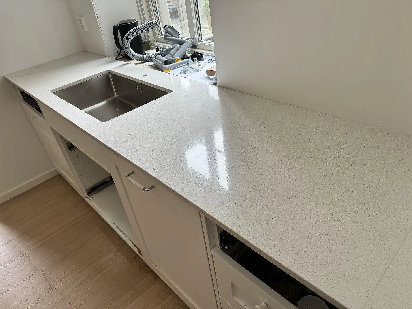 Köksbänkskiva i Silestone Blanco Maple 14, polerad komposit, med underlimmad rostfri diskho och vita luckor i Malmö.